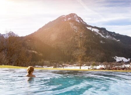 Eine Frau schwimmt in einem See. Im Hintergrund ist ein See.