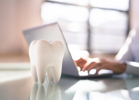 Zahnmodell vor einem Laptop