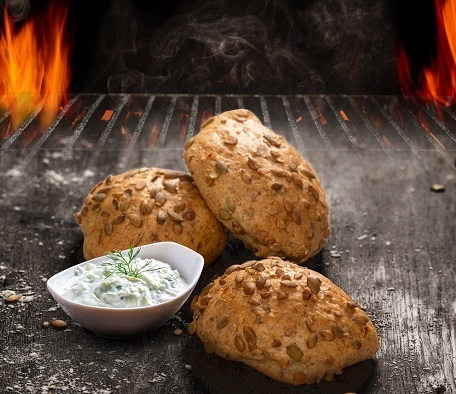 Drei Brötchen mit Quarkdip auf einer Holzfläche