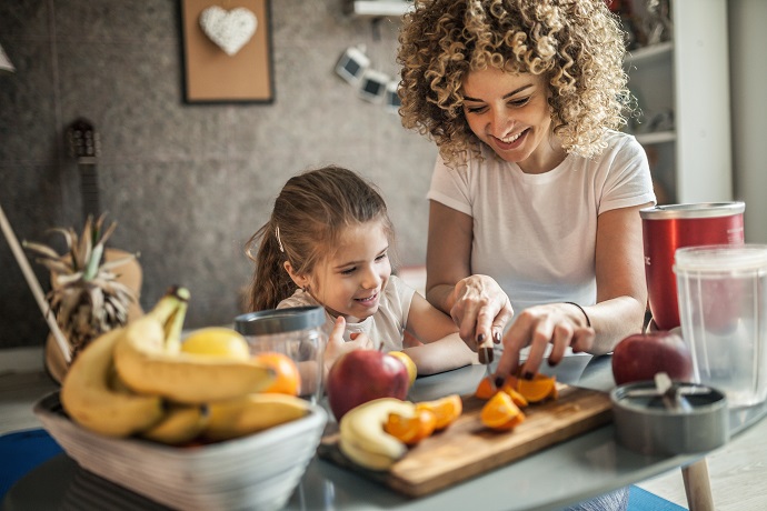 Mutter und Tochter machen Smoothie